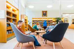Ihmisiä lukemassa Turun pääkirjastossa nojatuoleilla.