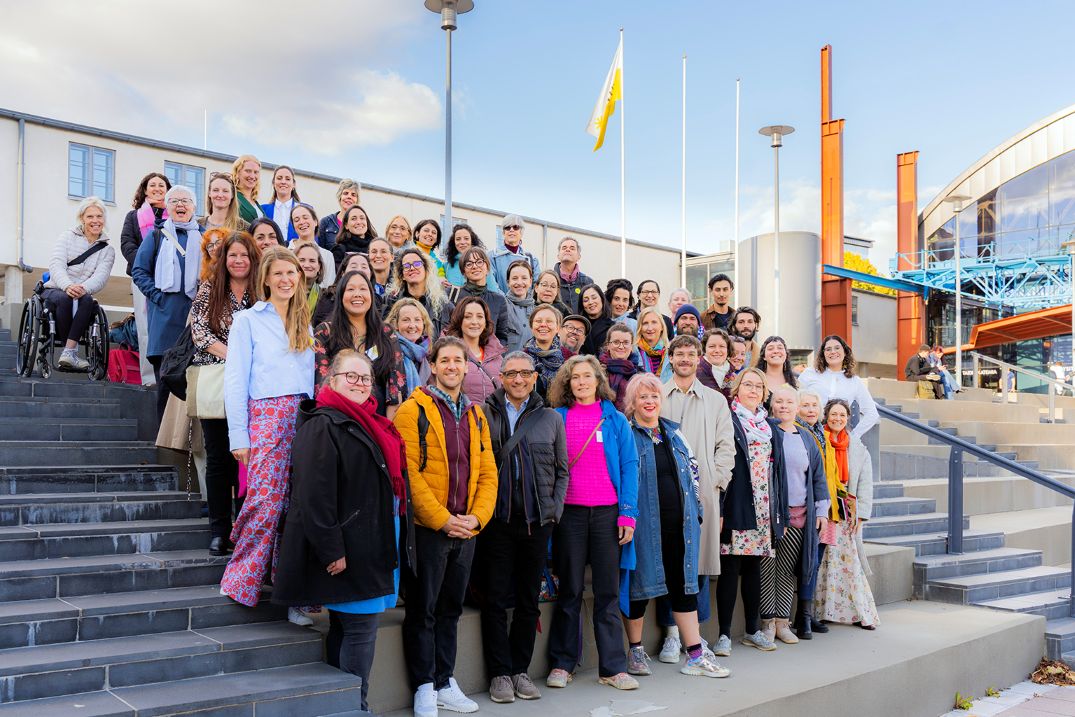 Joukko iloisia ihmisiä seisoo portailla.