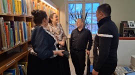 Neljä henkilöä keskustelemassa kirjastossa.