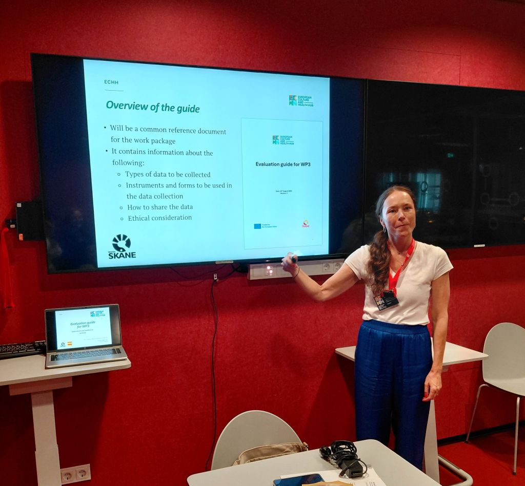 A person presenting in front of a screen with text.