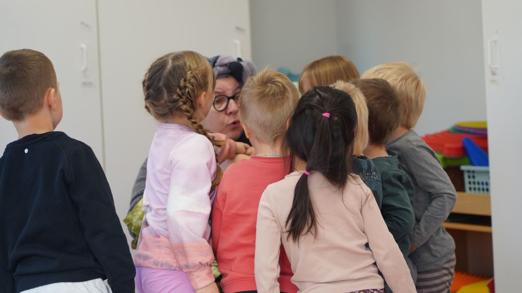 Lapset ovat kerääntyneet Piia Kleimolan ympärille hieman kaoottisesti.