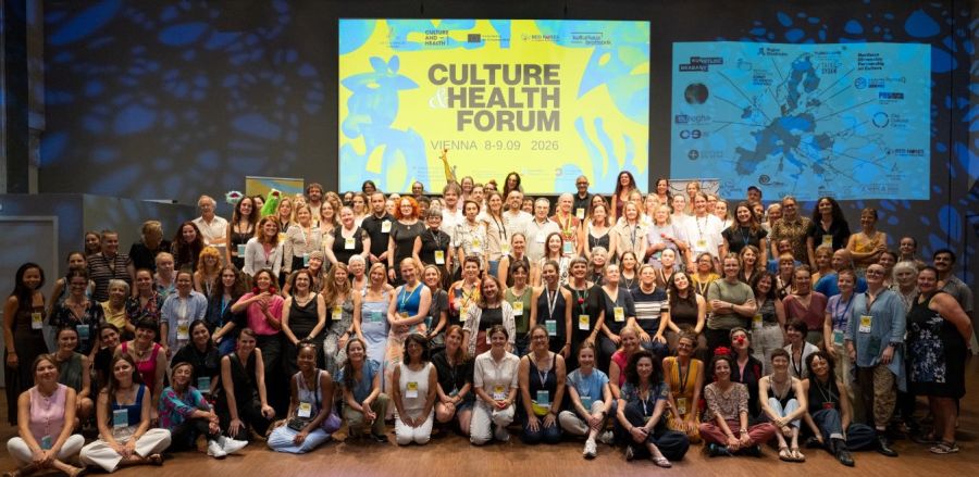 Suuri joukko ihmisiä ryhmäkuvassa, taustalla teksti Culture and Health Forum Vienna.